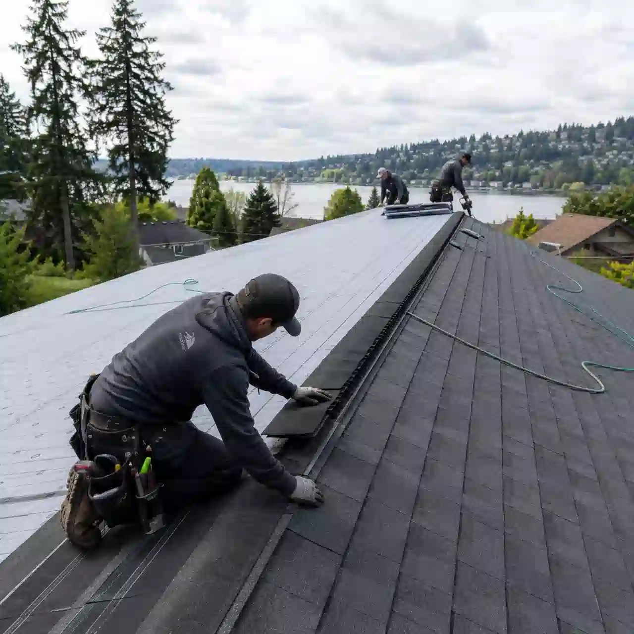 Renton Roofing crew installing ridge cap shingles overlooking the lake